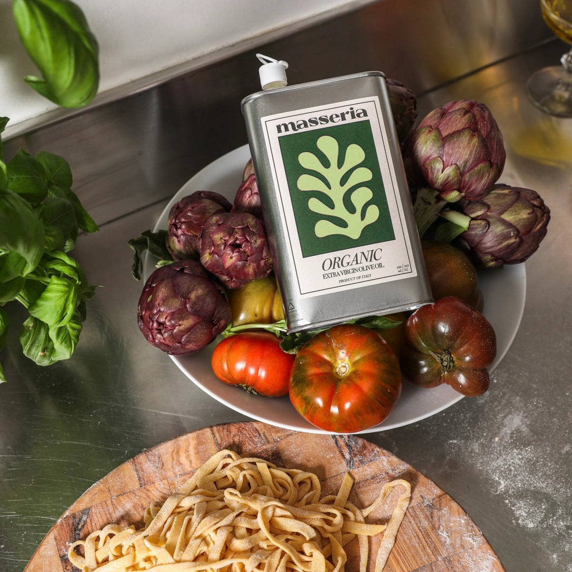organic olive oil bottle with fresh vegetables on a kitchen counter