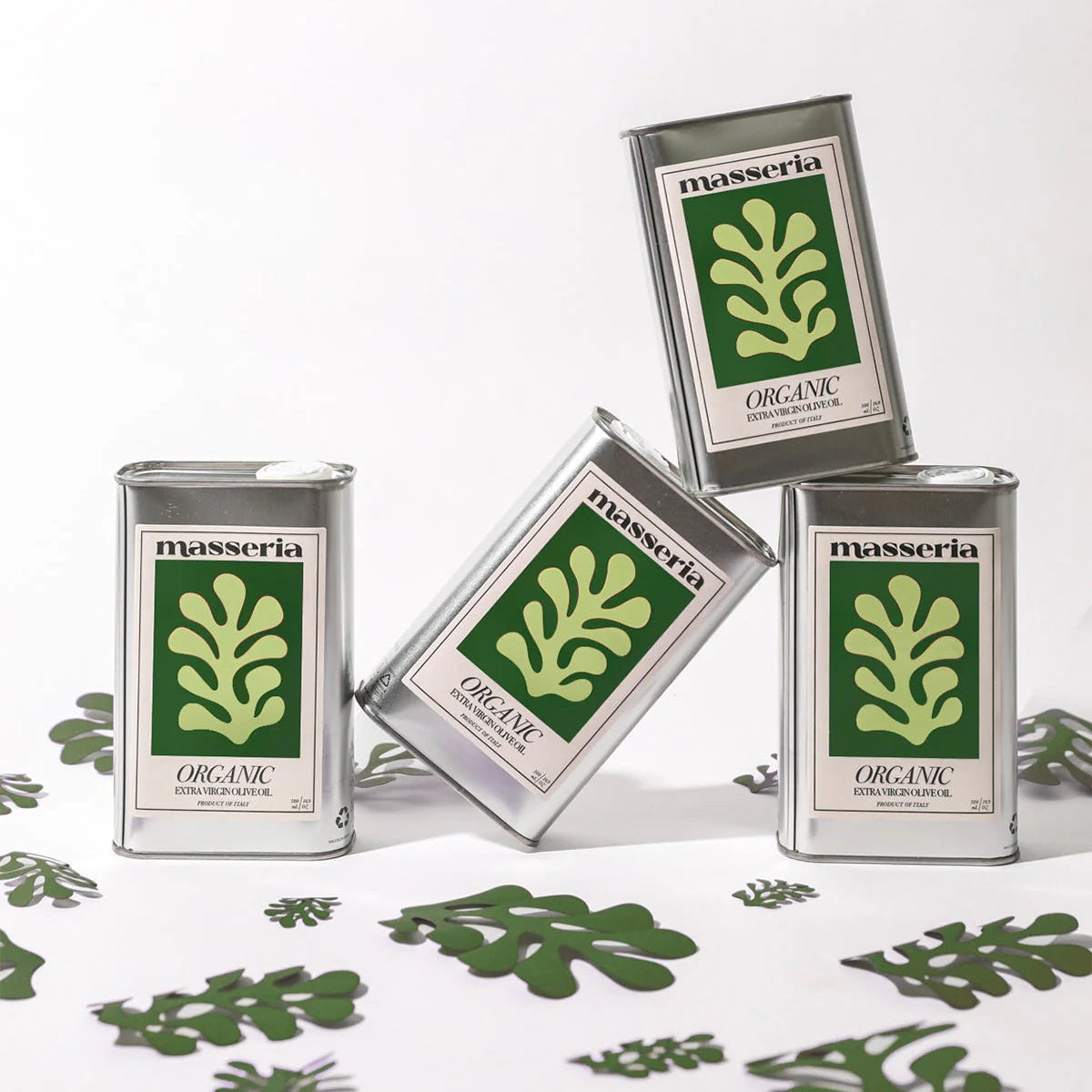 Four tins of Masseria Organic on a white background with green leaf patterns.